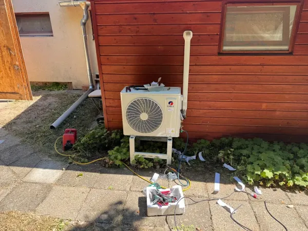 Kültéri egység állványon, faburkolatú fal mellett